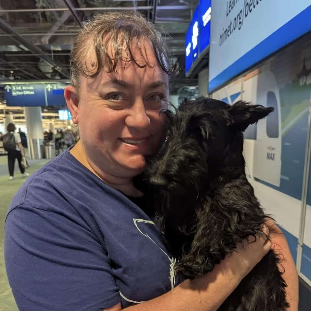 Dr. Anjeanette Garland holdng a black Scottish Terrier and smiling